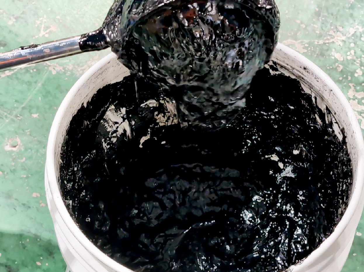 容器からすくい上げられた高粘度スラリー